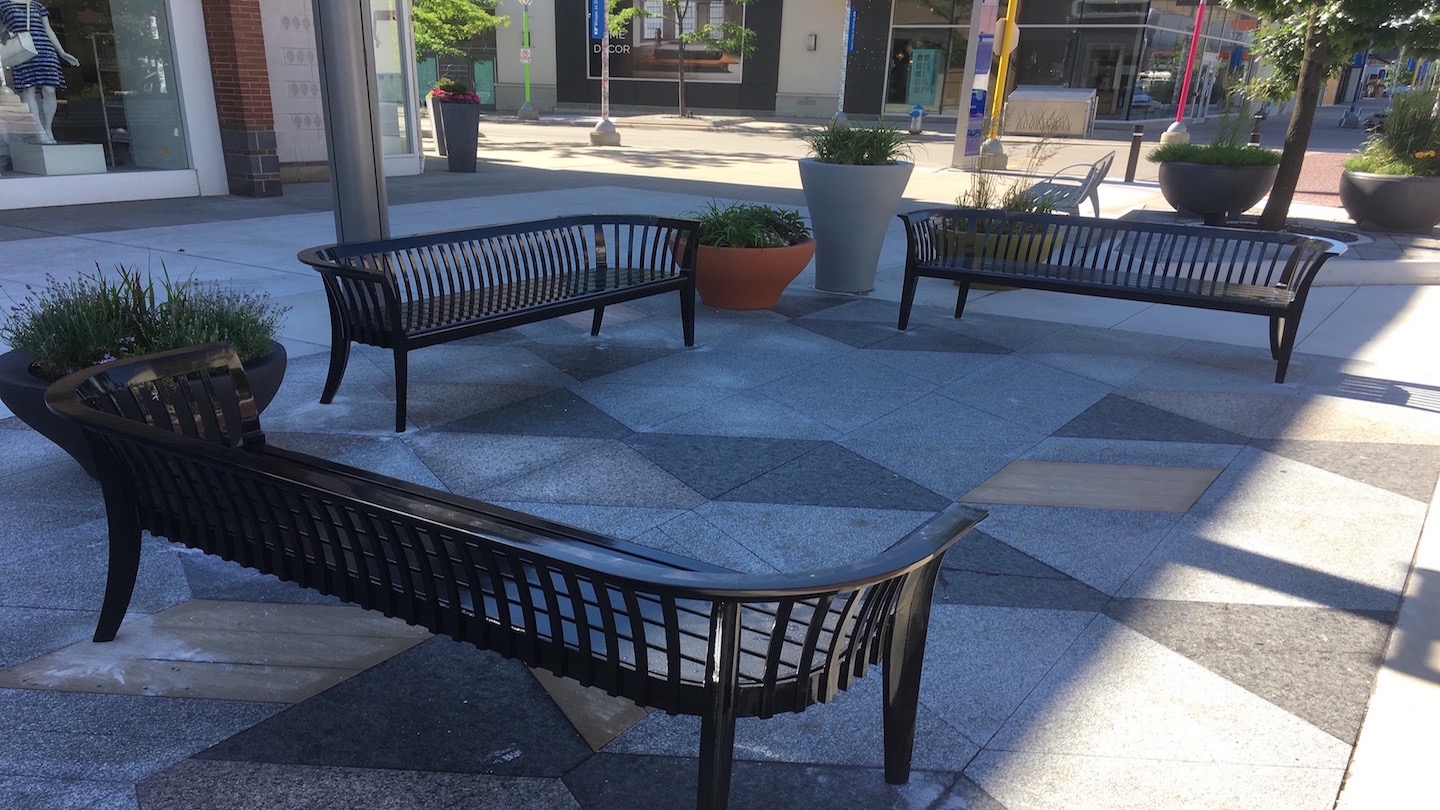 Custom outdoor benches installed on a sidewalk.