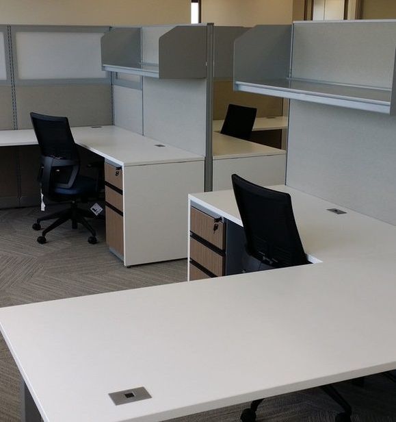 A cubicle set with desk and office chairs delivered and installed in an office.